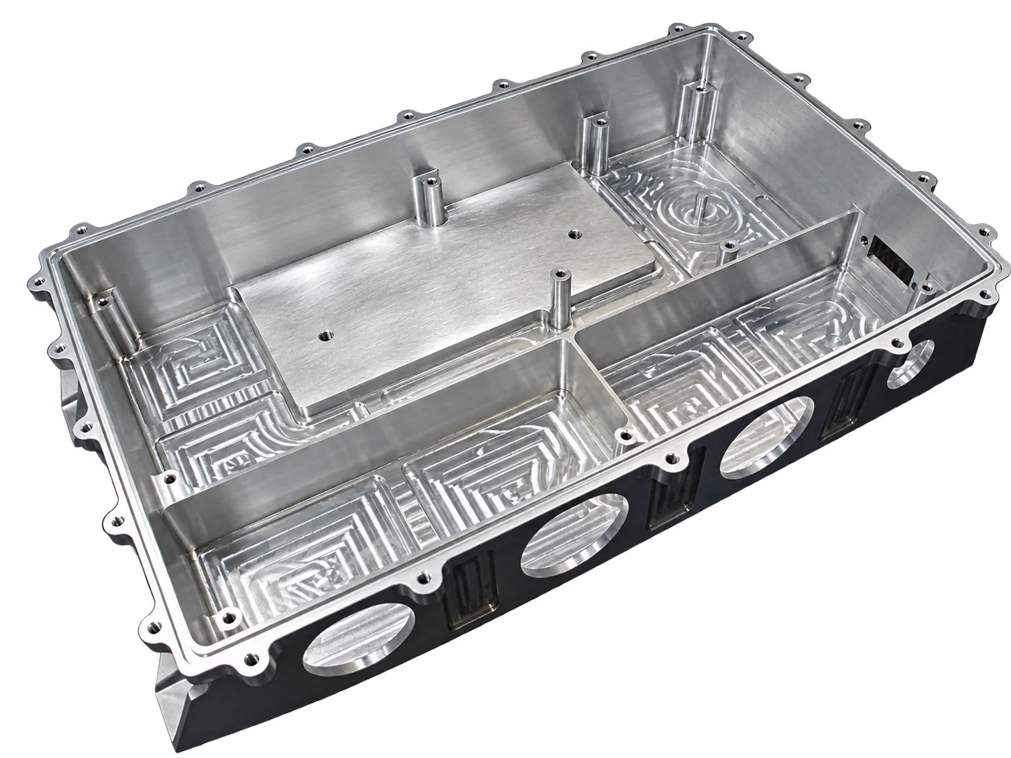Boîtier rectangulaire en aluminium usiné posé sur une surface sombre, avec compartiments, colonnettes, ouvertures rondes et motifs de fraisage au fond.